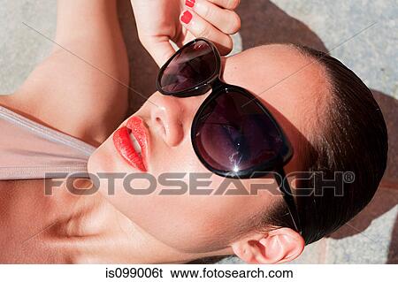 Stock Photograph - Woman wearing sunglasses, close up. Fotosearch