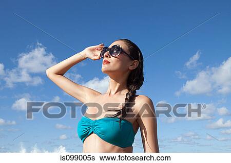 Woman wearing sunglasses shielding eyes View Large Photo Image Stock Photograph - Woman wearing sunglasses shielding eyes. Fotosearch