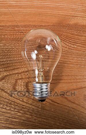 Lightbulb against wooden background View Large Photo Image Stock Photo - Lightbulb against wooden background. Fotosearch
