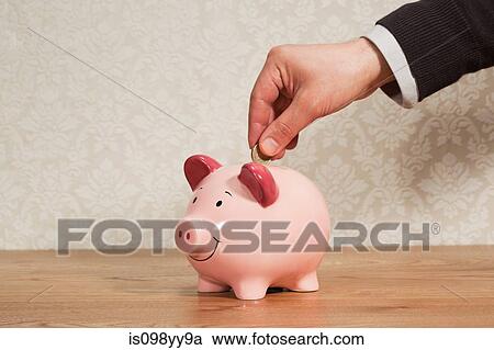 Man inserting pound coin into piggy bank View Large Photo Image Stock Image - Man inserting pound coin into piggy bank. Fotosearch