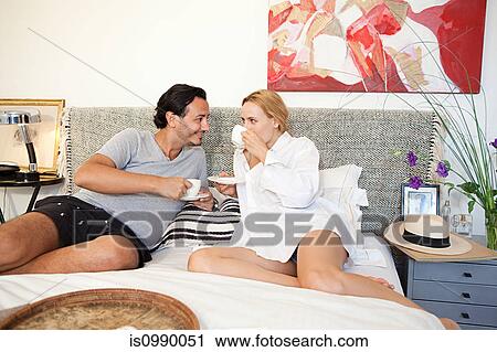 Couple having coffee in bed View Large Photo Image Stock Image - Couple having coffee in bed. Fotosearch