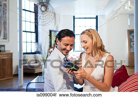 Stock Image - Man giving gift to wife. Fotosearch