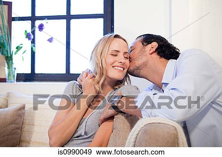 Man kissing wife on cheek View Large Photo Image Stock Photo - Man kissing wife on cheek. Fotosearch