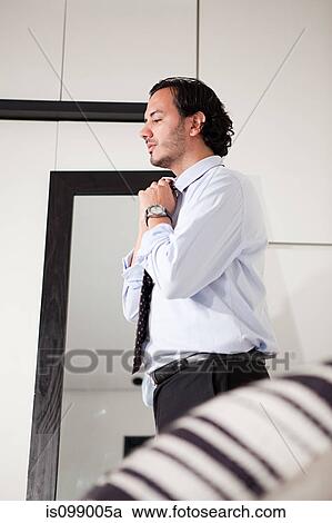 Man tying his tie View Large Photo Image Stock Image - Man tying his tie. Fotosearch