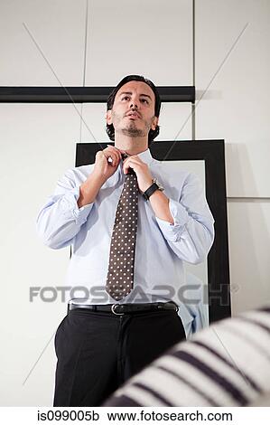 Man tying his tie View Large Photo Image Stock Image - Man tying his tie. Fotosearch