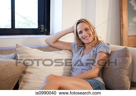 Stock Image - Woman relaxing on sofa. Fotosearch