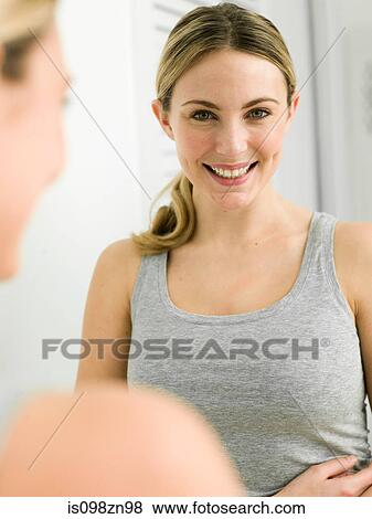 Reflection of young woman in bathroom mirror View Large Photo Image Stock Photo - Reflection of young woman in bathroom mirror. Fotosearch