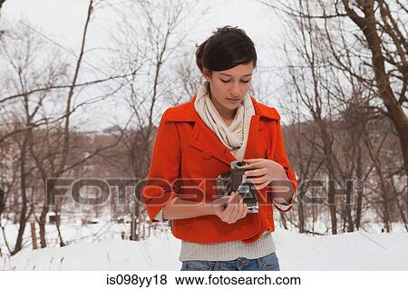 Teenage girl holding vintage camera in snow View Large Photo Image Stock Photo - Teenage girl holding vintage camera in snow. Fotosearch