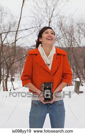 Teenage girl holding vintage camera in snow View Large Photo Image Stock Photo - Teenage girl holding vintage camera in snow. Fotosearch