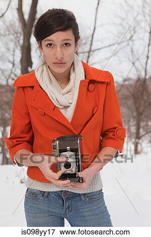Stock Photo - Teenage girl holding vintage camera, portrait. Fotosearch