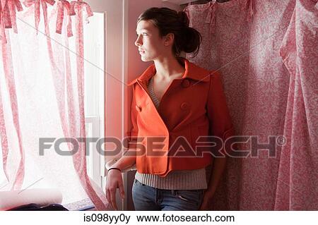 Stock Photo - Teenage girl looking out of bathroom window. Fotosearch
