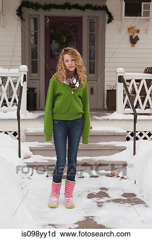 Stock Image - Teenage girl outside house, portrait. Fotosearch