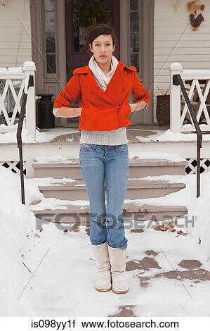 Stock Image - Teenage girl outside house, portrait. Fotosearch