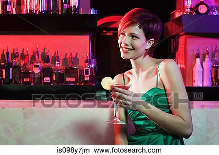 Happy young woman sitting at cocktail bar View Large Photo Image Picture - Happy young woman sitting at cocktail bar. Fotosearch