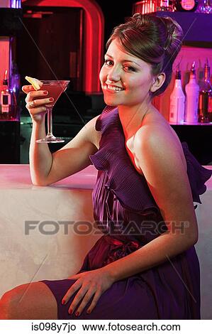 Happy young woman sitting at cocktail bar View Large Photo Image Picture - Happy young woman sitting at cocktail bar. Fotosearch