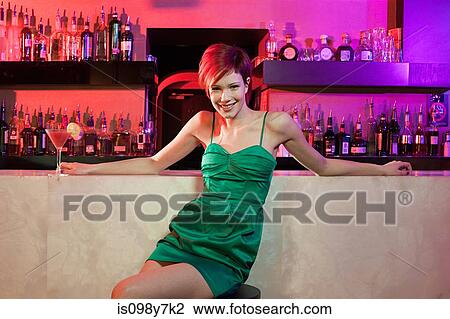 Happy young woman sitting at cocktail bar View Large Photo Image Stock Image - Happy young woman sitting at cocktail bar. Fotosearch