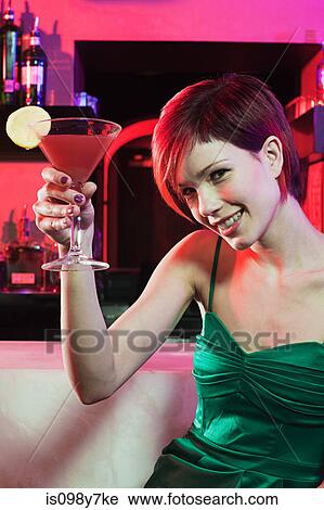 Happy young woman sitting at cocktail bar View Large Photo Image Stock Image - Happy young woman sitting at cocktail bar. Fotosearch