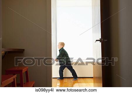 Stock Image - Boy playing in hallway. Fotosearch