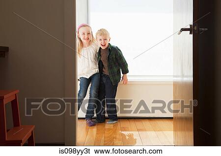 Stock Photograph - Brother and sister sitting on windowsill. Fotosearch