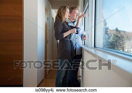 Stock Image - Couple looking through window. Fotosearch