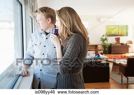 Stock Photograph - Couple looking through window. Fotosearch