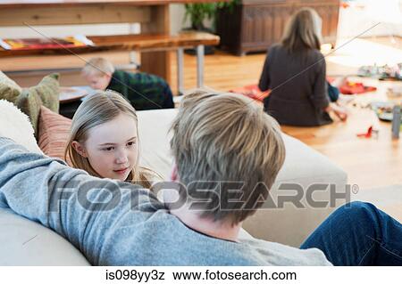 Family relaxing in living room View Large Photo Image Stock Photo - Family relaxing in living room. Fotosearch