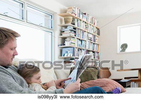 Stock Image - Father and daughter reading newspaper. Fotosearch