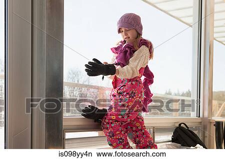 Girl getting dressed in winter clothing View Large Photo Image Picture - Girl getting dressed in winter clothing. Fotosearch