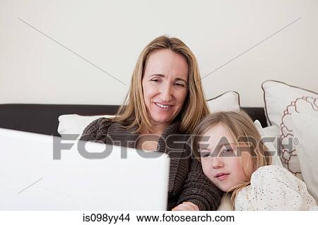 Picture - Mother and daughter using laptop. Fotosearch
