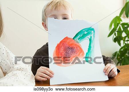 Picture - Young boy holding up painting. Fotosearch