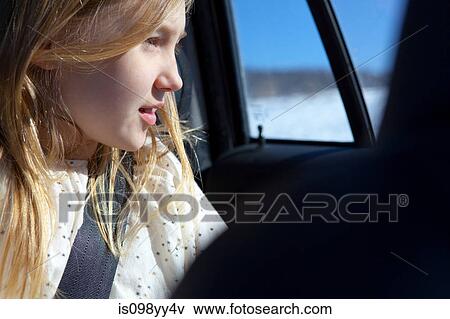 Young girl looking through car window View Large Photo Image Stock Photo - Young girl looking through car window. Fotosearch