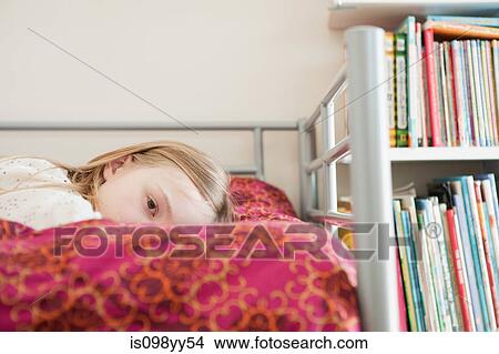 Picture - Young wistful girl lying on bed. Fotosearch
