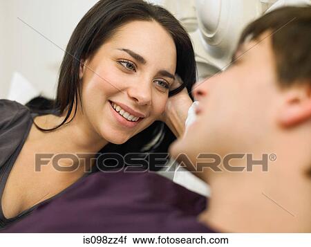 Stock Image - Young couple in bed, close up. Fotosearch
