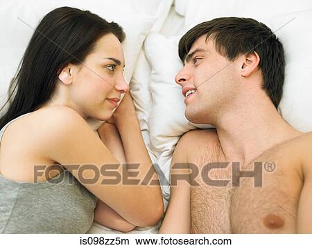 Young couple lying in bed face to face View Large Photo Image Picture - Young couple lying in bed face to face. Fotosearch