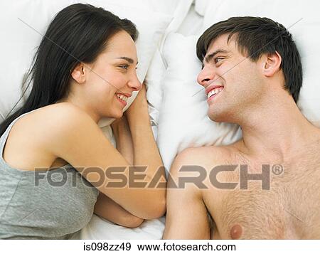 Young couple lying in bed View Large Photo Image Stock Photo - Young couple lying in bed. Fotosearch