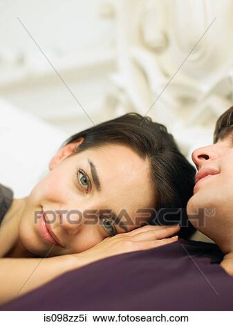Young couple lying in bed, woman's head on man's shoulder View Large Photo Image Stock Image - Young couple lying in bed, woman's head on man's shoulder. Fotosearch
