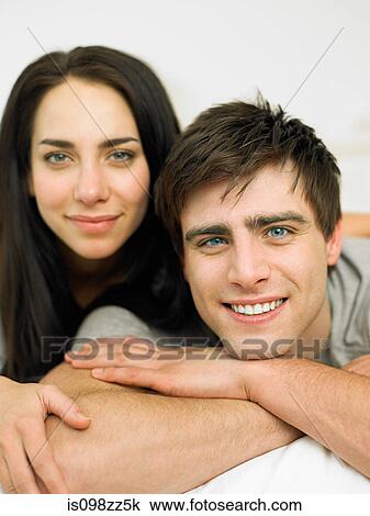 Young couple lying on front, portrait View Large Photo Image Stock Image - Young couple lying on front, portrait. Fotosearch