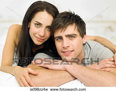 Stock Photo - Young couple lying on front, portrait. Fotosearch