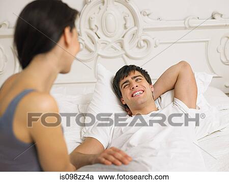 Stock Image - Young couple on bed together. Fotosearch