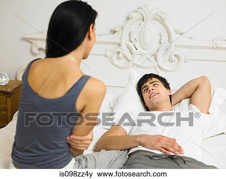 Stock Photo - Young couple on bed together. Fotosearch