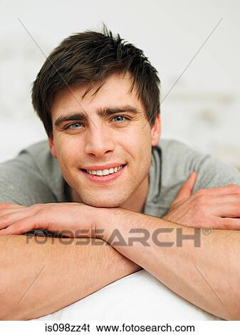 Young man lying on front, portrait View Large Photo Image Stock Photograph - Young man lying on front, portrait. Fotosearch