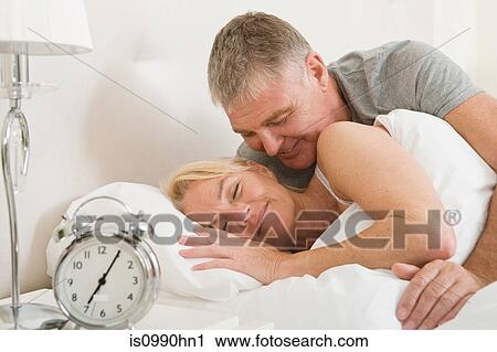 Couple in bed, waking up View Large Photo Image Stock Image - Couple in bed, waking up. Fotosearch