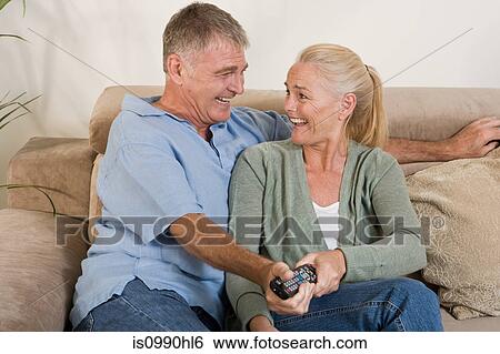 Mature couple both holding a remote control View Large Photo Image Stock Photograph - Mature couple both holding a remote control. Fotosearch