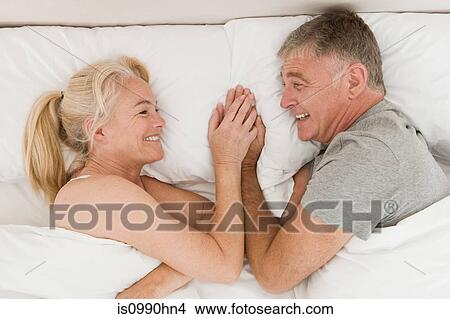 Mature couple holding hands in bed View Large Photo Image Picture - Mature couple holding hands in bed. Fotosearch