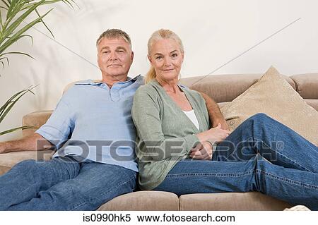 Stock Photography - Mature couple sitting on sofa. Fotosearch