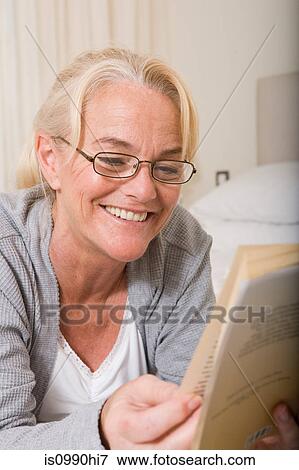 Stock Photo - Mature woman reading a book. Fotosearch