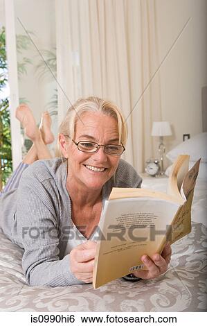 Mature woman reading a book View Large Photo Image Stock Photograph - Mature woman reading a book. Fotosearch