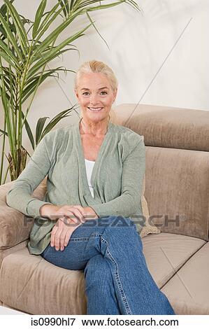 Mature woman sitting on sofa View Large Photo Image Stock Photo - Mature woman sitting on sofa. Fotosearch