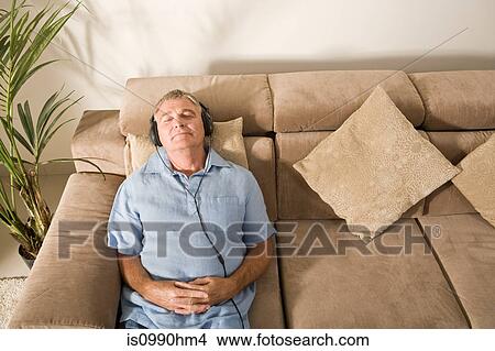 Senior man relaxing with headphones on View Large Photo Image Picture - Senior man relaxing with headphones on. Fotosearch