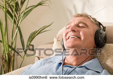 Senior man relaxing with headphones on View Large Photo Image Stock Photograph - Senior man relaxing with headphones on. Fotosearch